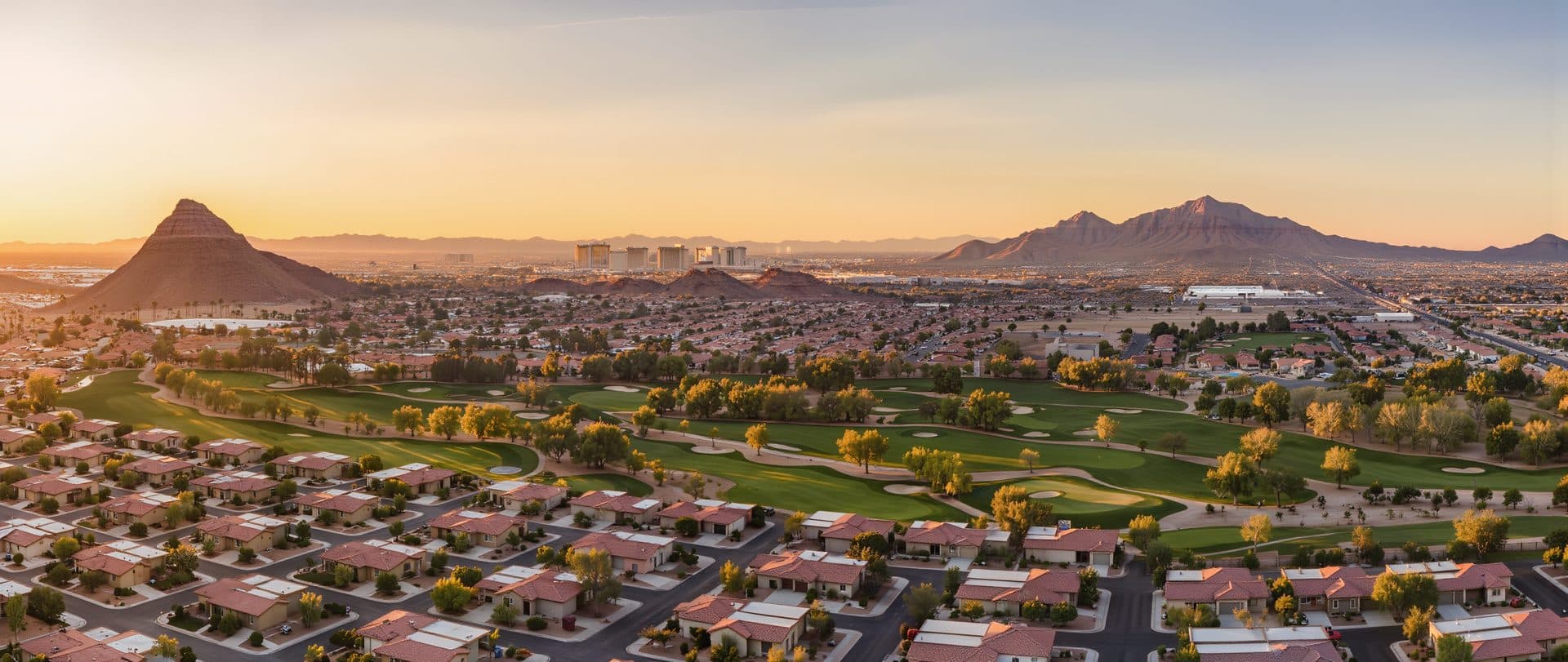 Aerial view of Las Vegas valley neighborhoods and golf courses at sunrise